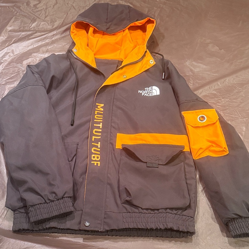 The North Face Kids Raincoat - Black and bold gold.